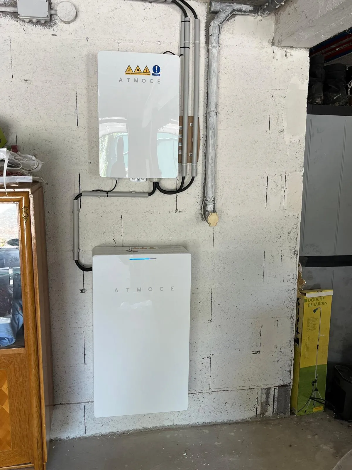 Batterie de stockage Atmoce et son onduleur installés par ISL CLIM dans un garage