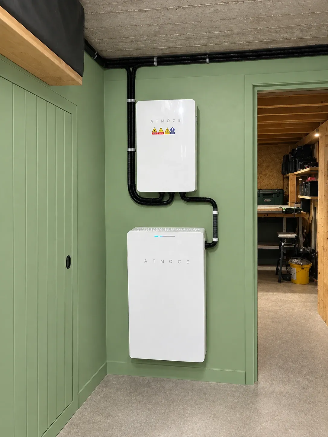 Système de stockage Atmoce fixé au mur d’un local technique, câblage sous gaines