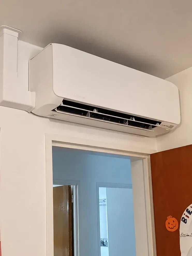 Unité intérieure de climatisation murale installée par ISL CLIM au-dessus de la porte d’une chambre