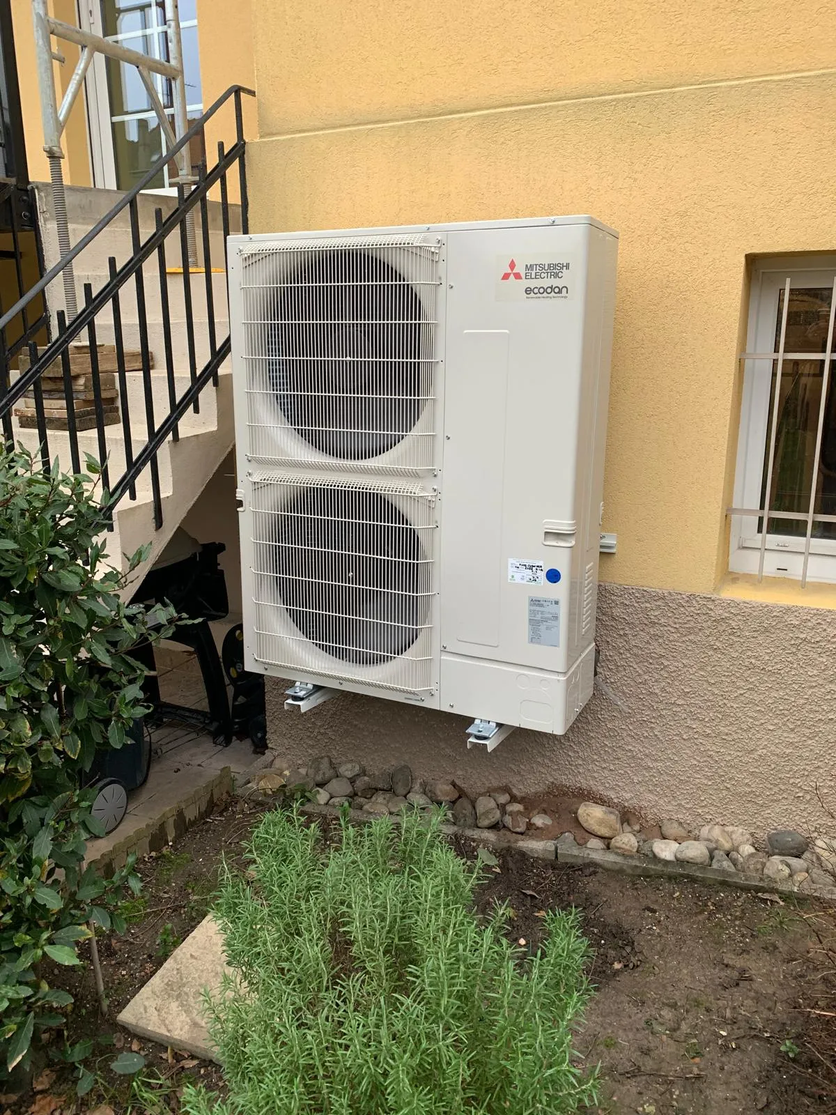 Pompe à chaleur air/eau Mitsubishi Electric Ecodan installée par ISL CLIM contre la façade d’une maison en Alsace