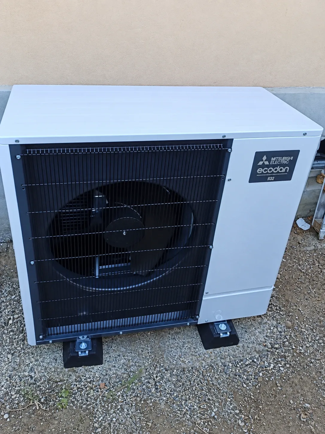 Pompe à chaleur air/eau Mitsubishi Electric Ecodan R32 installée par ISL CLIM sur plots antivibratiles, le long d’une façade