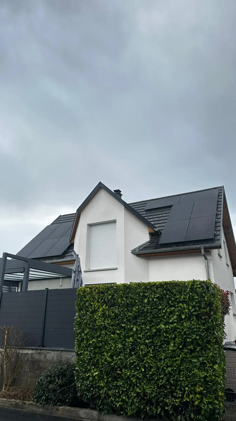 Maison blanche dont les deux pans de toiture sont couverts de panneaux photovoltaïques installés par ISL CLIM
