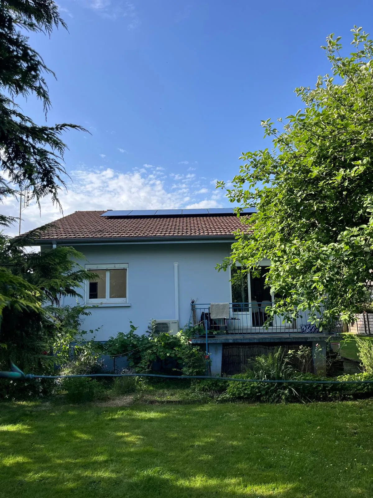 Vue depuis le jardin d’une maison alsacienne équipée de panneaux photovoltaïques par ISL CLIM