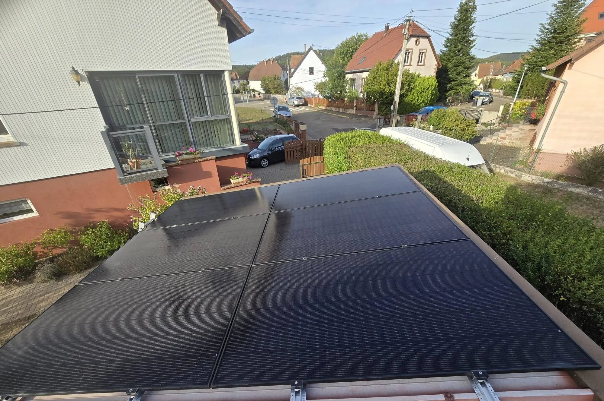 Six panneaux photovoltaïques installés par ISL CLIM sur un toit plat, dans un quartier résidentiel